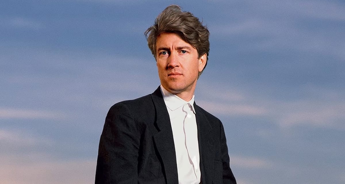 Director David Lynch stands outdoors in front of Packard vehicle in Los Angeles in 1986.