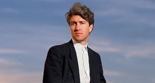 Director David Lynch stands outdoors in front of Packard vehicle in Los Angeles in 1986.